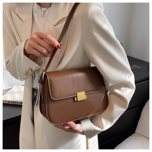 Close-up of a vintage brown leather bag featuring an elegant gold square metal buckle