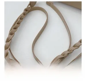 Detailed close-up of the beige woven leather strap with lychee grain texture