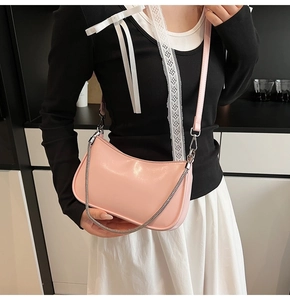 Detail view of pink patent leather baguette bag with silver chain strap and zipper