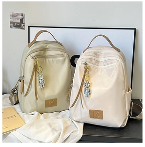 Detailed view of waterproof travel backpacks with brown leather handles and bear charms