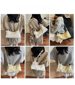 Detail view of cream underarm bag with decorative mesh bow and pearl tassel accents