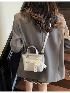 Borsa a secchiello metallizzata argento con fiocco in pizzo e ciondolo a cuore