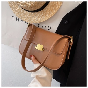 Detail of caramel faux leather shoulder bag with a gold rectangular metal clasp
