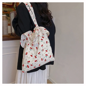 Detail of ruffled edge tote bag with red cherry pattern and Magic Pocket label