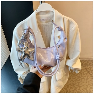 Détail du sac croissant en cuir verni plissé lilas avec breloques étoile et chien