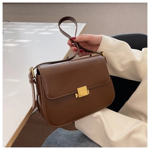 Detail of a brown leather crossbody bag with a square gold metallic buckle clasp