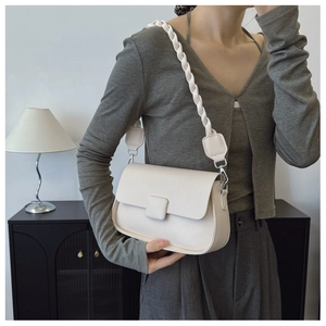 Close-up of cream textured leather crossbody bag with chic woven shoulder strap detail