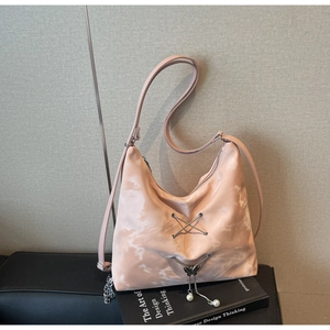 Detail of pink marble pattern hobo bag with butterfly pendant on a design book
