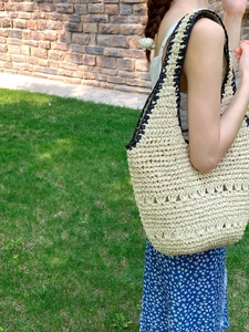 Handmade woven straw tote bag with black trim edge and hollow pattern for summer beach