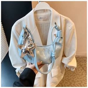 Détail du sac croissant en cuir verni bleu clair avec breloques étoile et chien ballon