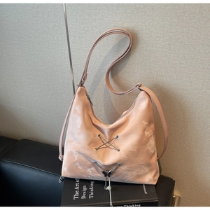 Detail of pink tie-dye tote bag with metal eyelets, butterfly charm and pearl tassel