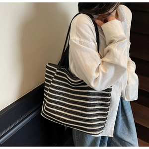 Detail shot of black and white woven texture on a large capacity tote bag with slim shoulder strap
