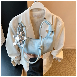 Détail du sac croissant bleu clair avec pendentif étoile argentée et nœud sur l'anse