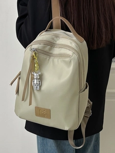 Waterproof khaki travel backpack with multi-layer zippers and silver bear charm pendant