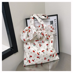 Detail view of cherry print canvas tote bag with elegant ruffled edges and fabric texture