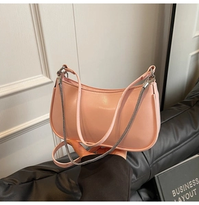 Detail view of pink crescent bag with silver chain and detachable leather shoulder strap