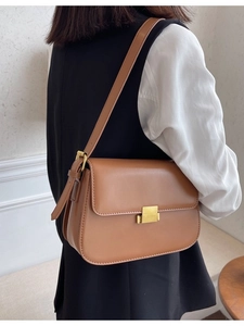 Vintage brown leather crossbody bag with square gold buckle shown on a model