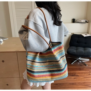 Detail of colorful woven rainbow tote bag with premium brown leather shoulder straps