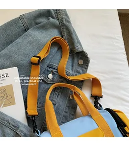 Detail of adjustable strap on blue and yellow contrast canvas Boston shoulder bag