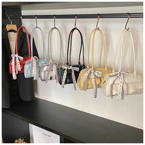 Chic multi-color shoulder bags with silk scarves displayed on a modern boutique rack
