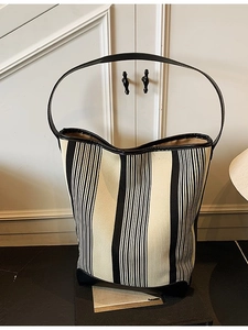 Minimalist black and white striped canvas bucket bag with premium leather trim and handles