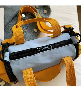 Detail view of smooth metal ring zipper and yellow nylon webbing on a blue Boston bag