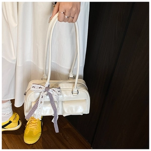 Detail of off-white PU leather bowling bag featuring plaid bow and front flap pockets