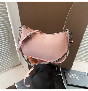 Detail of pink faux leather baguette bag with metal chain strap and adjustable belt