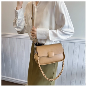Detail of khaki crossbody bag featuring pebble texture and braided leather shoulder strap