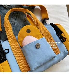 Detail of Boston bag front pocket with magnetic closure for wireless earphone storage