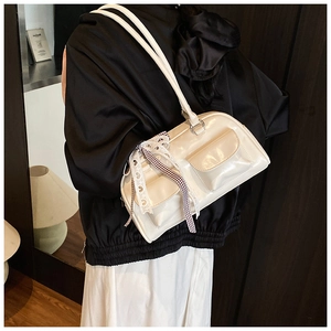 Detail of white patent leather shoulder bag with checkered bow and lace ribbon decor