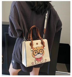 Detail of the cartoon cat pattern and wide shoulder strap on the white tote bag