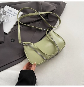 Detail of light green crescent hobo bag with silver chain on professional attire