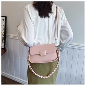 Detail of pink woven texture crossbody bag shown from behind with adjustable straps