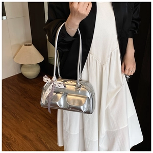 Detail view of silver metallic bowling bag with small front pockets and silk bow accent