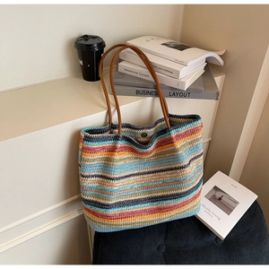 Detail of multi-color woven tote bag with brown leather handles and magnetic snap button