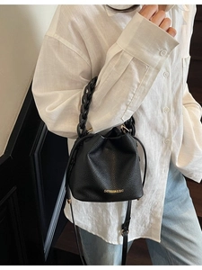 Elegant black lychee grain bucket bag with woven handle and gold logo detail