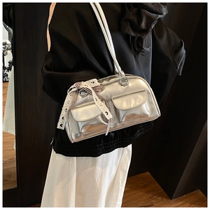 Macro view of silver metallic PU shoulder bag with lace bow and front flap pockets