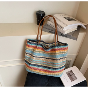 Detail of colorful woven rainbow tote bag with durable brown handles and large capacity