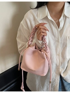 Pink pebbled leather bucket bag with woven handle and drawstring closure for women