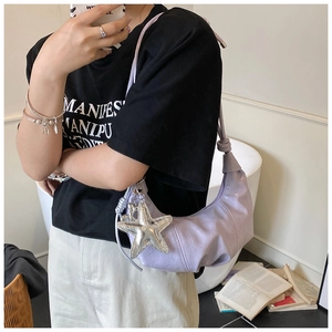 Détail du sac croissant lilas avec texture plissée et breloque étoile argentée