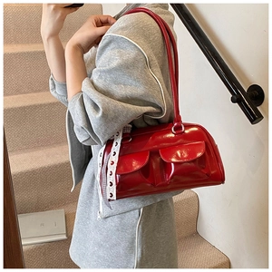 Detail of red patent leather bowling bag with twin front pockets and lace accents