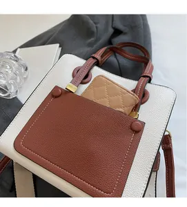 Close-up of leather tote bag with exterior pocket and quilted coin purse detail