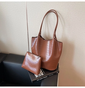 Brown crocodile pattern tote bag set with matching zipper pouch on a fashion book