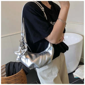 Gros plan d'un sac demi-lune argenté avec pendentif étoile et texture plissée élégante
