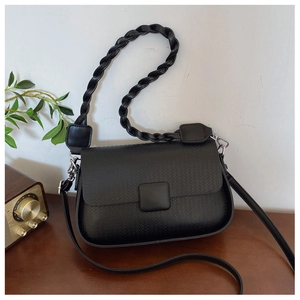 Detail of black crossbody bag with woven texture, chunky handle and square buckle
