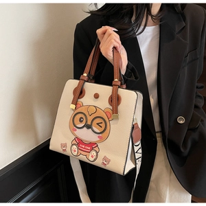 Close-up of beige lychee leather tote bag with cartoon bear and LOVE wide shoulder strap