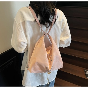 Pink satin backpack featuring pearl butterfly charms and elegant criss-cross lace details