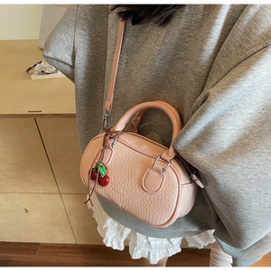 Pink croc-embossed mini Boston bag with cherry charm and cross-body strap detail