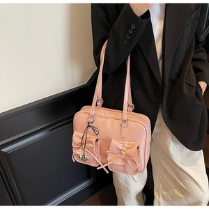 Borsa tote rosa stile balletto con fiocchi e ciondolo a cuore indossata dalla modella